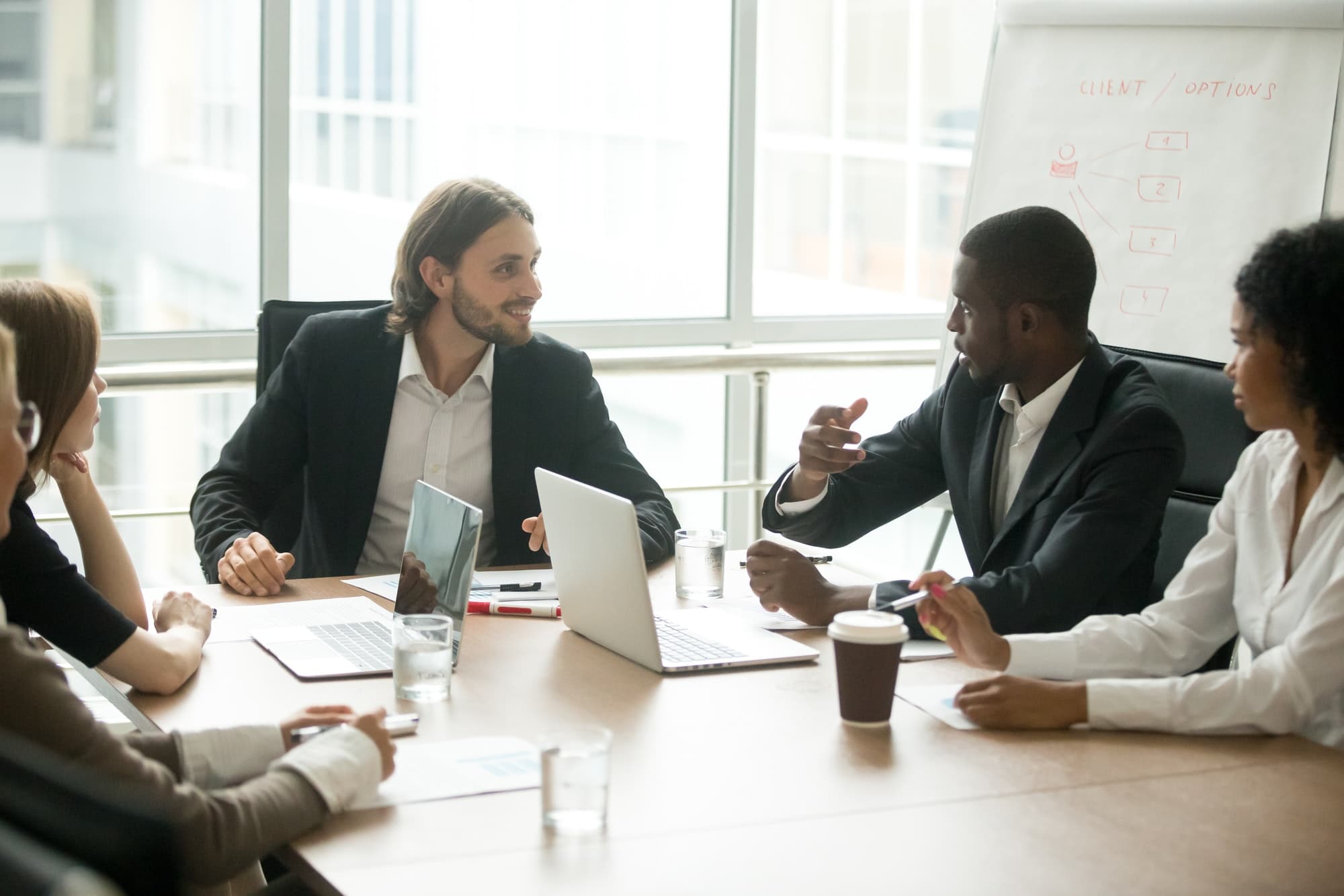 Business executives discussing project ideas at team meeting conference table