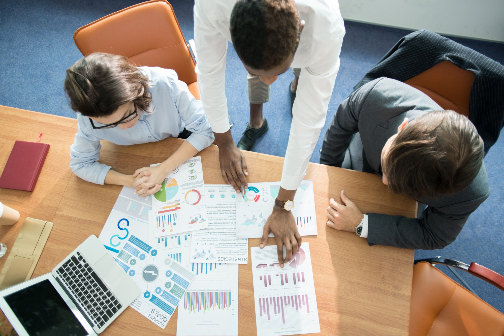 Marketing team analyzing statistics at meeting